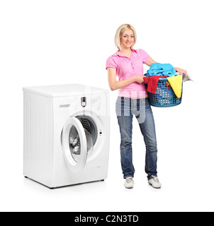 A full length portrait of a woman carrying a laundry basket and washing machine isolated on white Stock Photo