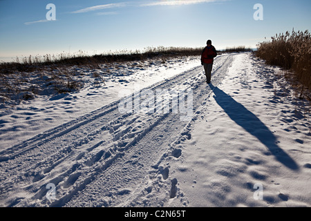 Silhouette of woman walking in snow Newport Wetlands Wales UK Stock Photo