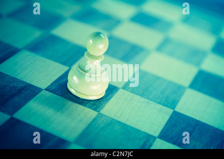 White pawn down on the chessboard . Black and white retro style toned conceptual photo with shallow DOF Stock Photo