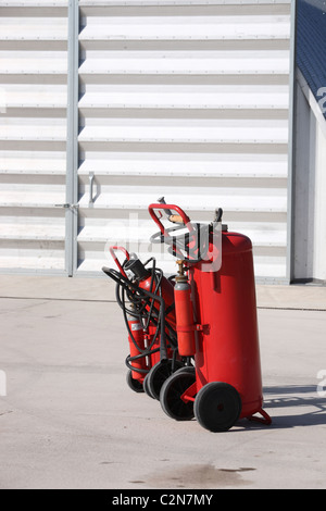Fire extinguisher trolley by hanger door Stock Photo