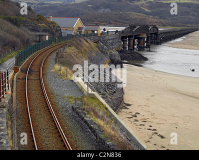 Train tracks railway line Barmouth Bridge over Mawddach Estuary at low tide in winter Gwynedd mid Wales UK United Kingdom GB Great Britain Stock Photo