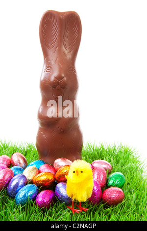 Milk chocolate easter bunny and colorful eggs on grass over white background Stock Photo