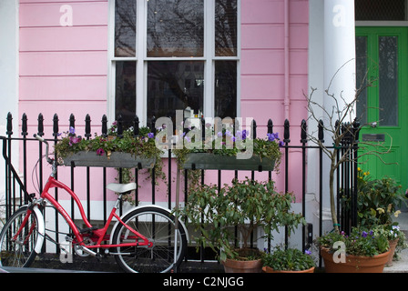 A bicycle parked in front of one of the coloured terrace houses of Chalcot Square, near Primrose Hill, London, NW1, England