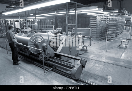 A man, blue collar worker, working with his hands in a clothing and fabric factory. Stock Photo