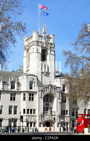 Union Jack & Emblem UKSC flags flying above stone tower old Middlesex Guildhall building now UK Supreme Court in Parliament Square London England UK Stock Photo