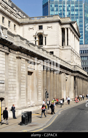 People on London Threadneedle Street pavement beside façade of Bank of England Building in the financial district of the City of London England UK Stock Photo