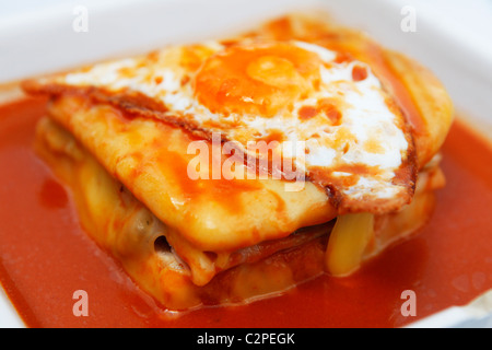 A Francesinha sandwich, topped with a fried egg, is served in Porto, Portugal. Stock Photo