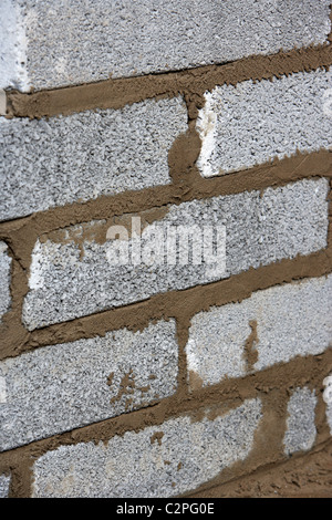 bricklaying wall with half cement breeze blocks building a block retaining wall in the uk Stock Photo