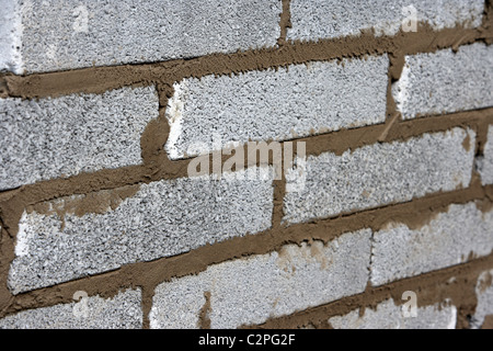 bricklaying wall with half cement breeze blocks building a block retaining wall in the uk Stock Photo