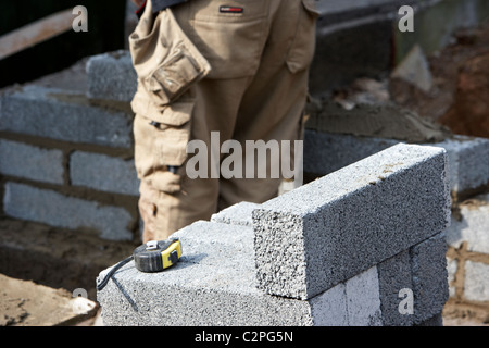 bricklaying wall with half cement breeze blocks building a block retaining wall in the uk Stock Photo