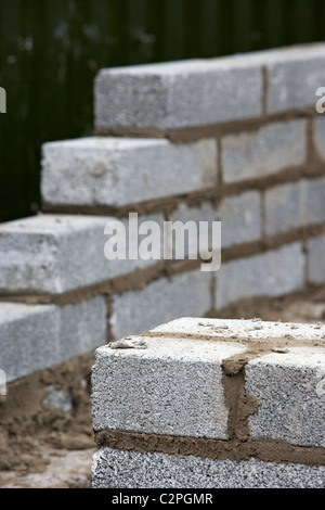 partially built wall with half cement breeze blocks building a block retaining wall in the uk Stock Photo