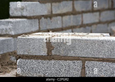 partially built wall with half cement breeze blocks building a block retaining wall in the uk Stock Photo