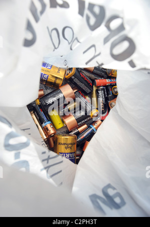 USED BATTERIES IN PLASTIC CARRIER BAG READY TO BE RECYCLED RE RECYCLING RECYCLE ENERGY ELECTRICAL GREEN ETC UK Stock Photo