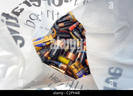 USED BATTERIES IN PLASTIC CARRIER BAG READY TO BE RECYCLED RE RECYCLING RECYCLE ENERGY ELECTRICAL GREEN ETC UK Stock Photo