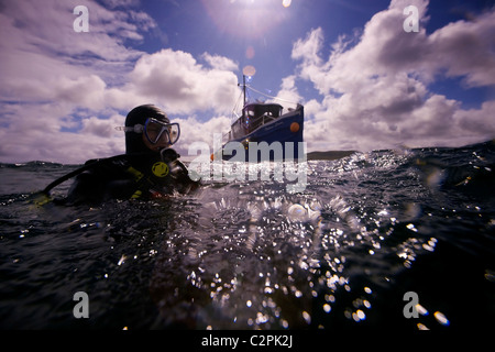 The dive boat 'Radiant Queen' approaches a diver on the surface above the wreck of the destroyer, F2, in Scapa Flow, Orkney Stock Photo