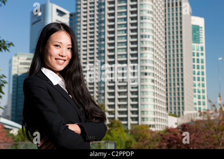 Smiling Japanese business woman in downtown district Stock Photo