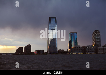 Sunset and a stormy sky over the Hudson River and Jersey City. The Goldman Sachs tower is the tallest building in New Jersey. Stock Photo