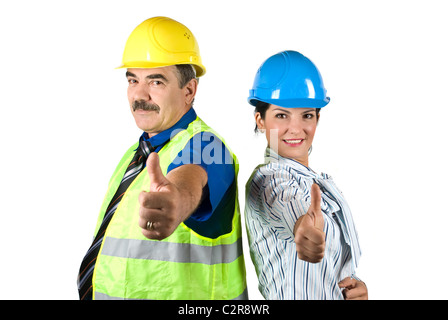 Two happy architects with hardhat standing back to back and giving thumbs -up isolated on white background Stock Photo