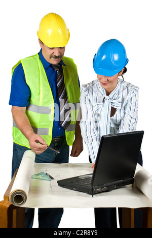 Two architects in office looking on plans , working with notebook and consulting each other about projects Stock Photo