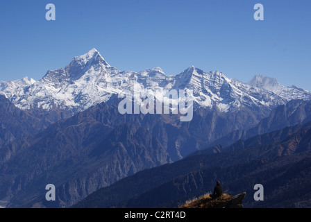 Garhwal Himalayas, India: A trekker takes in views of Dunagiri and Nanda Kot from beneath the Kuari Pass. Stock Photo