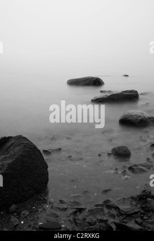Stones seen in the sea covered with fog Stock Photo