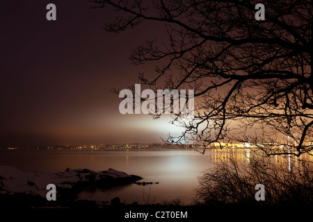 A night view over the winter northern sea on a city with bright lights Stock Photo
