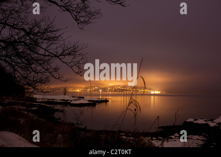A night view over the winter northern sea on an island with bright lights Stock Photo