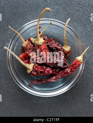 A Dish Of Whole Dried Kashmiri Chillies, Against A Slate Work Surface Stock Photo