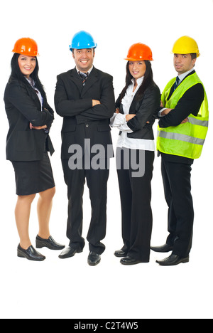 Full length of four architects standing in a row with hands crossed and wearing colorful helmets isolated on white background Stock Photo