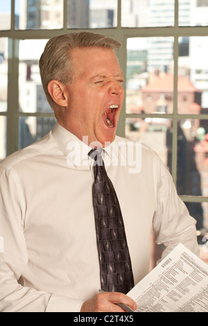 Yawning Mature Businessman at the Office Stock Photo