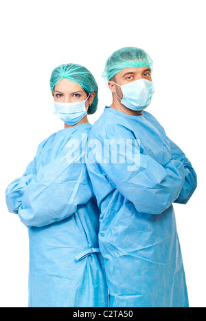 Two surgeons in sterile uniforms standing back to back with arms folded and looking camera isolated on white background Stock Photo