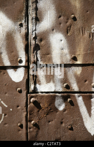 white graffiti on metal steel door in sun Stock Photo