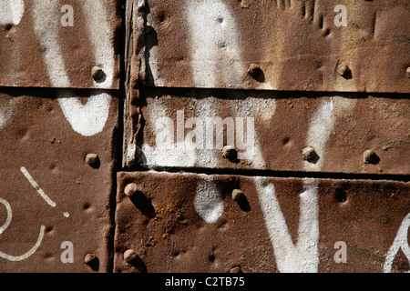 white graffiti on metal steel door in sun Stock Photo