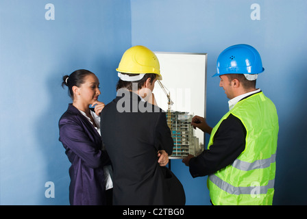 Two architect men's giving hand shakes and engineer woman laughing together and having fun Stock Photo