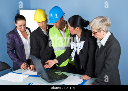 Architect team in office having a meeting a office ,a young engineer woman using laptop and they discuss together Stock Photo