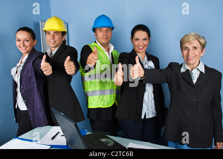 Five engineers team give thumbs up and smiling in a office showing successful in business Stock Photo