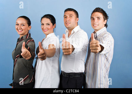 Four young business people team standing in a line and giving thumbs up Stock Photo