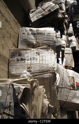 pile of old used newspapers left in street road in city town Stock Photo