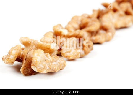 halves peeled walnuts arranged in a line on a white background Stock Photo