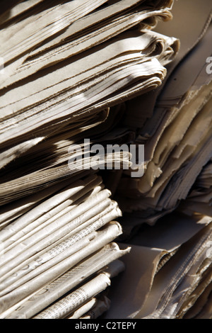 pile of old used newspapers left in street road in city town Stock Photo