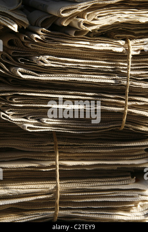 pile of old used newspapers left in street road in city town Stock Photo