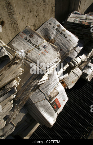 pile of old used newspapers left in street road in city town Stock Photo