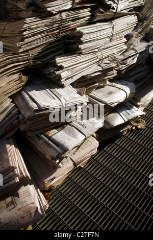 pile of old used newspapers left in street road in city town Stock Photo