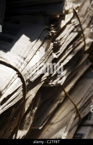 pile of old used newspapers left in street road in city town Stock Photo