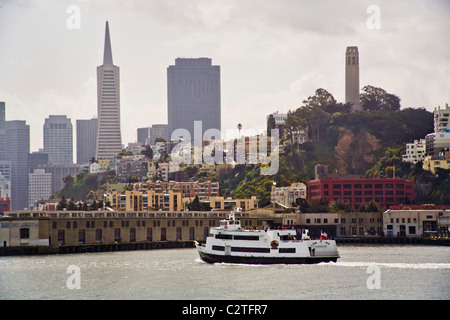 A tourist cruise boat to passes San Francisco's waterfront on the way to Alcatraz Island and its infamous prison. Note Transamer Stock Photo