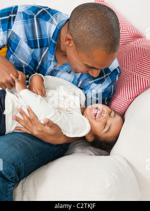 Father tickling daughter Stock Photo