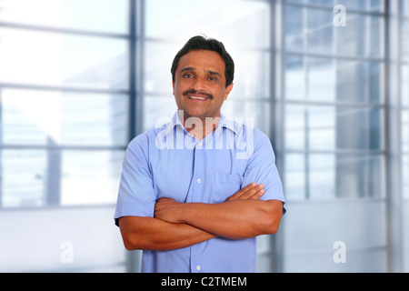Indian latin businessman blue shirt in modern office background Stock Photo