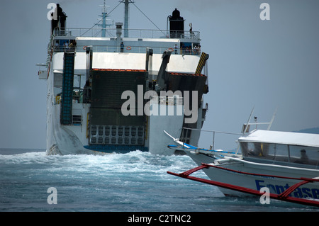 Philippine Super Ferry transports passengers across the seas off Puerto Galera, Mindoro, Philippines as does a smaller banca. Stock Photo