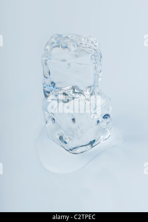 Close-up of two ice cubes slowly melting away in a puddle of water. Real Photo not a 3D render. Stock Photo