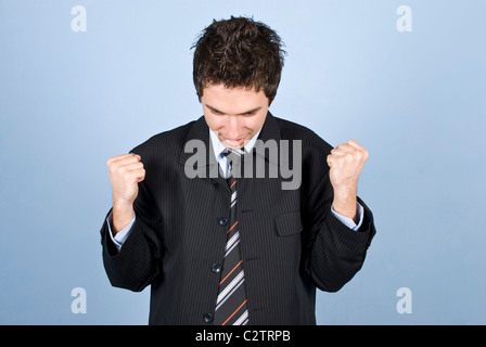 Cheering business man with successful business in front of blue background Stock Photo